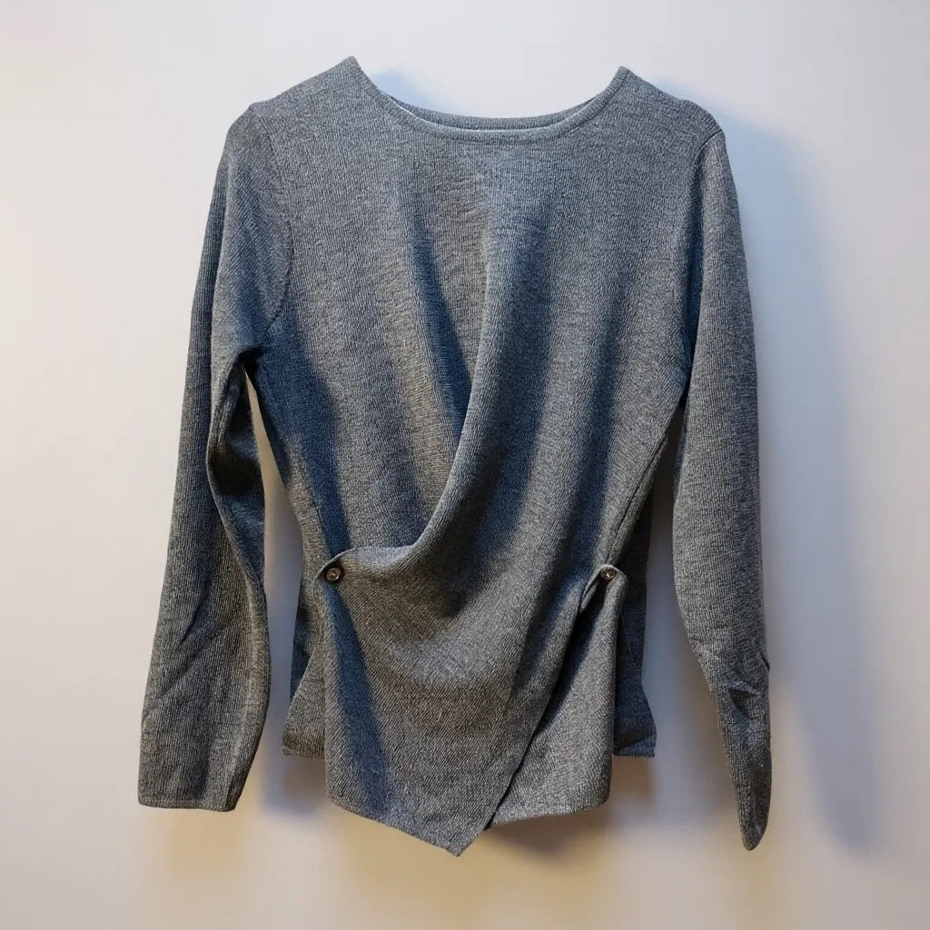 JJACollection grey knit asymmetrical long sleeve top with wrap-around design and button details.